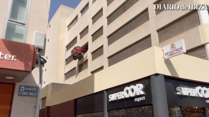 b08a6618-618e-4832-b9d1-9d7b6a94dbae_16-9-discover-aspect-ratio_default_0.jpg A car is left hanging from a fourth floor of a parking lot in Ibiza
