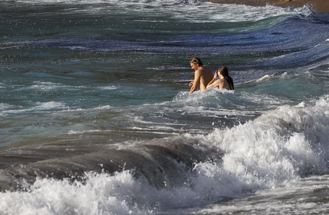 Two bathers in Benirràs (Ibiza) next to a blue tide of jellyfish / SANTI TUR @ATFUNK