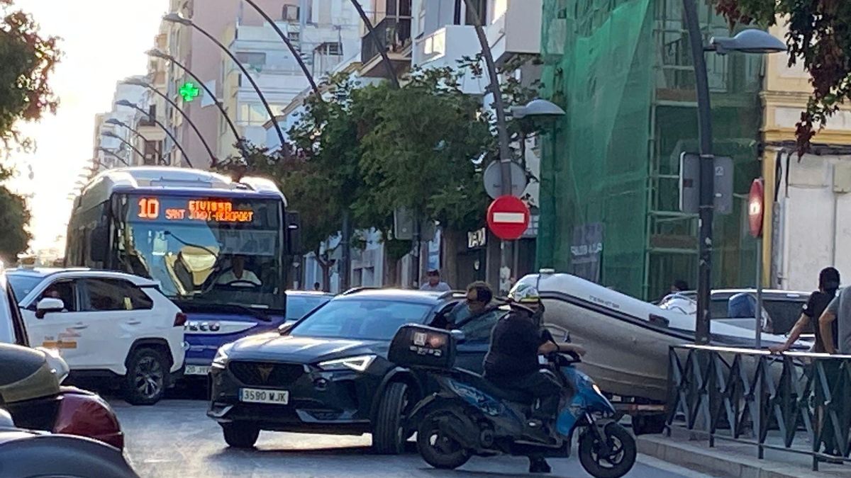 A car towing a dinghy gets stuck in an Ibiza avenue