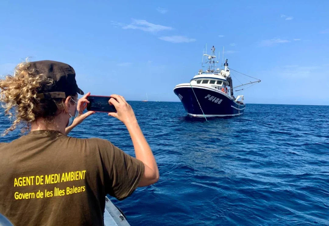 An environmental officer inspects a fishing boat. | CAIB