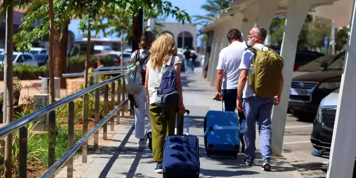 Tourists carry their suitcases upon arrival at Ibiza Airport. | Toni Escobar
