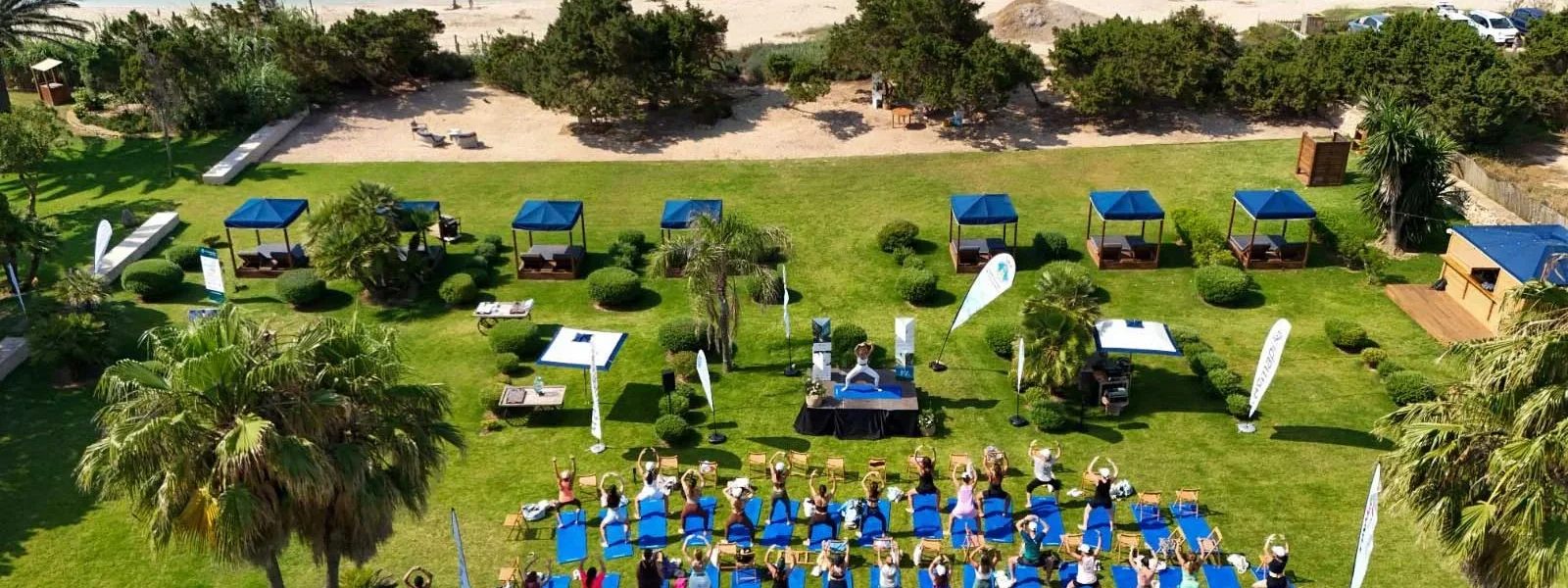 An outdoor yoga session during an edition of Formentera Zen, on the grass with the Mediterranean in the background. / Formentera Zen
