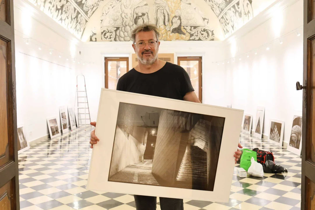 Joan Costa with one of his photographs while setting up the exhibition in the Refectori. / J.A. Riera